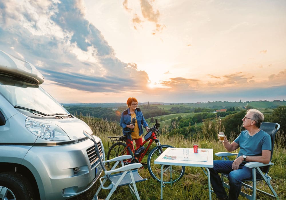 Couple relaxing by motorhome